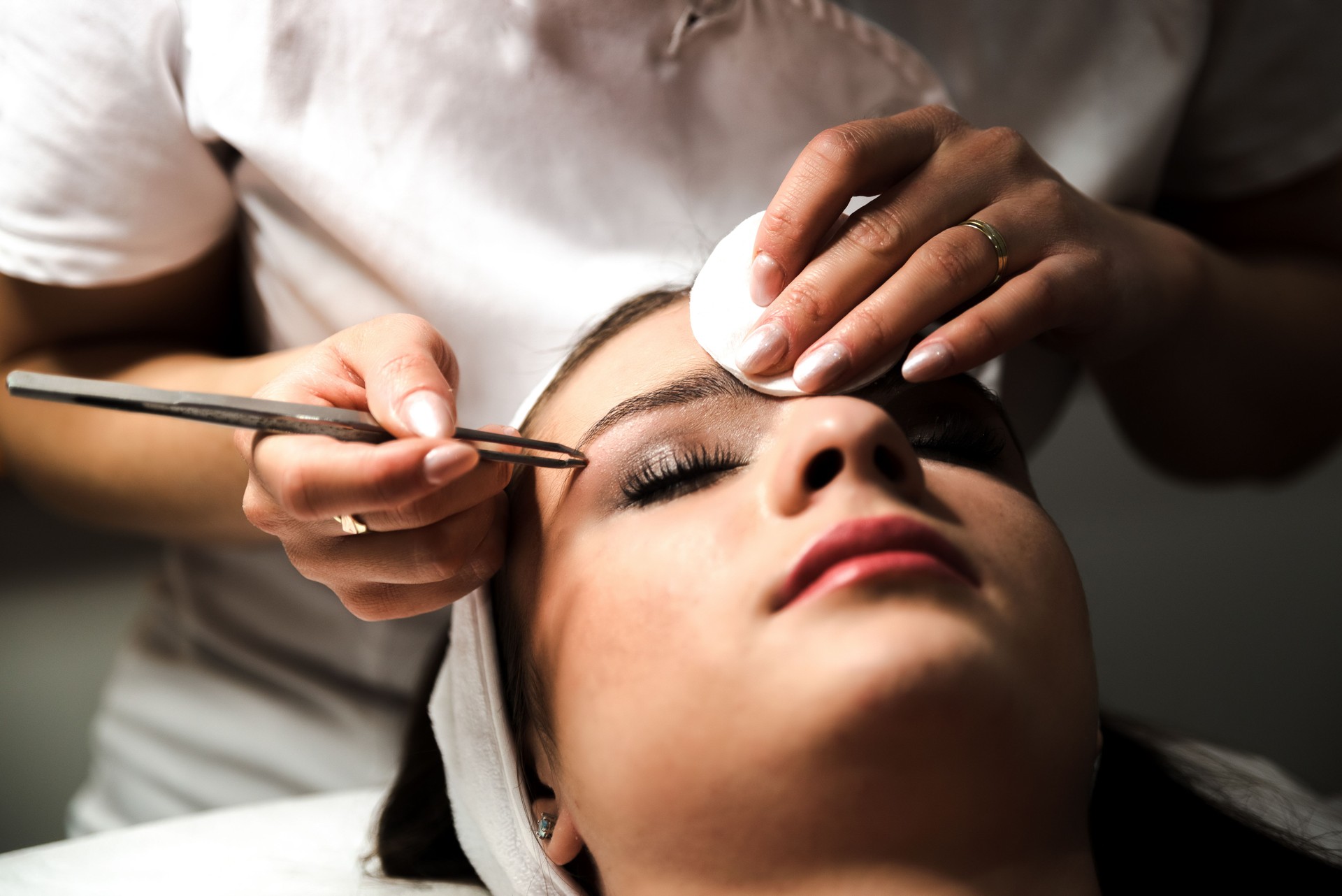 Kosmetikerin, die Wimpernverlängerung im Schönheitssalon durchführt. Permanentes Wimpern-Make-up